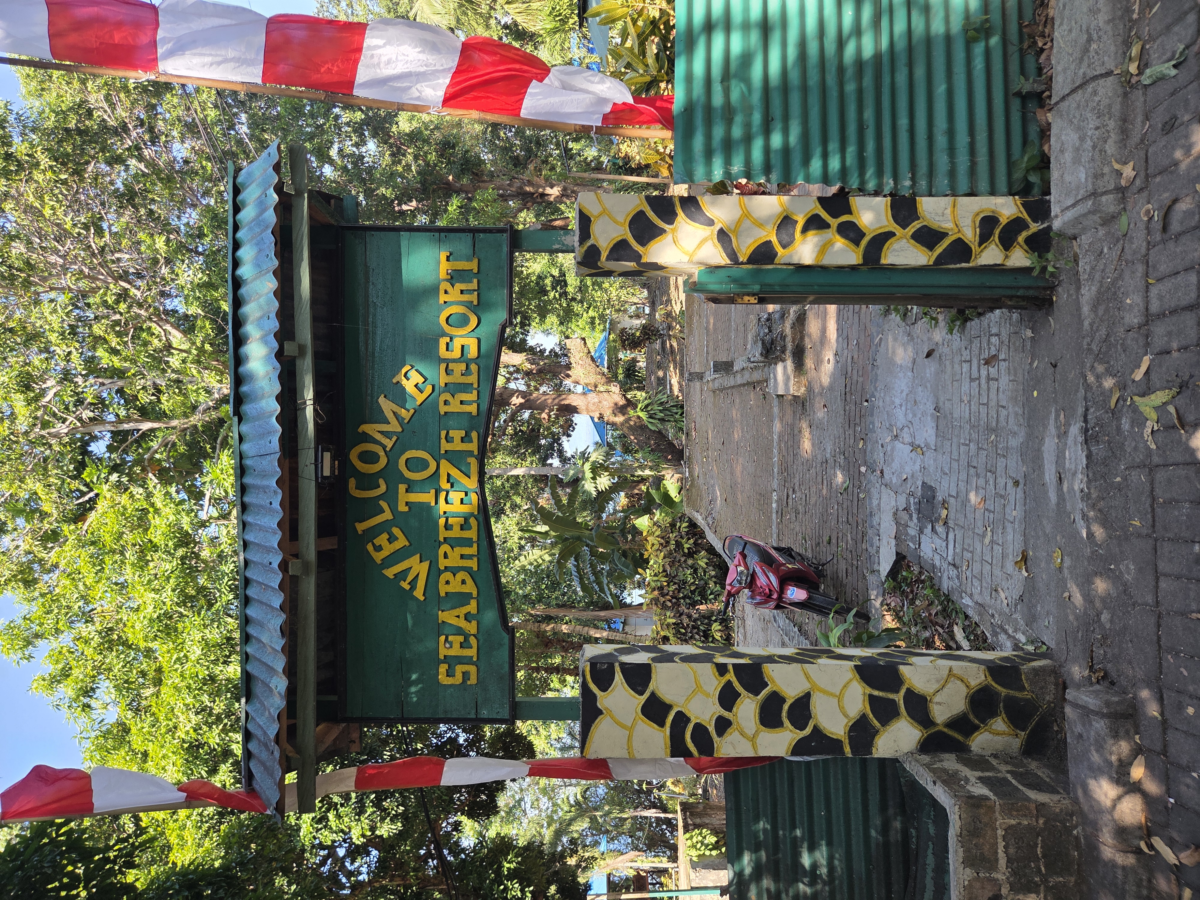 The timber entrance gate to Seabreeze Resort, strung with red-and-white flags